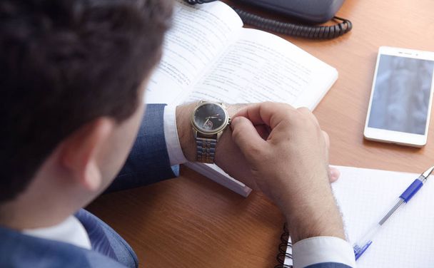 Ο επιχειρηματίας ρυθμίζει το ρολόι - Φωτογραφία, εικόνα