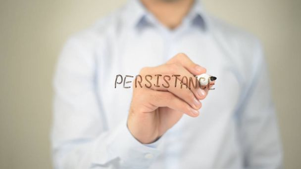 Persistencia, hombre escribiendo en pantalla transparente
 - Foto, Imagen
