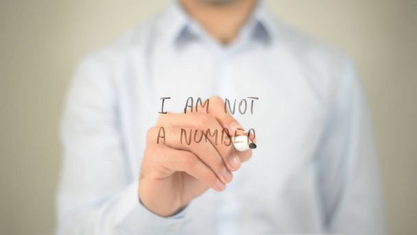 I Am Not A Number, hombre escribiendo en pantalla transparente
 - Foto, imagen