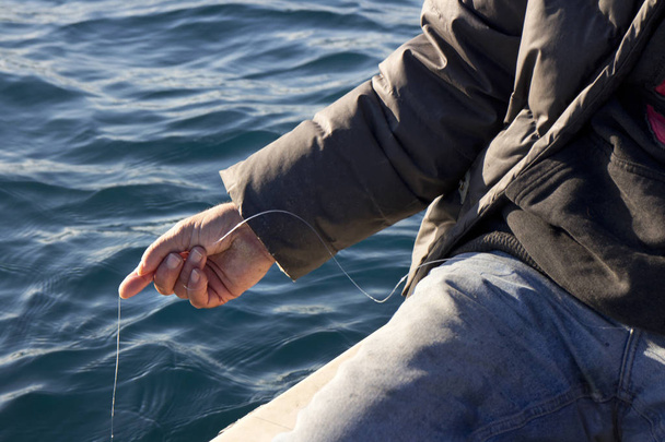 Ręka z żyłki przed błękitne morze - Zdjęcie, obraz