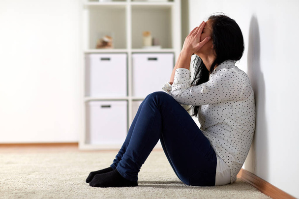 unhappy woman crying on floor at home - Foto, Imagem