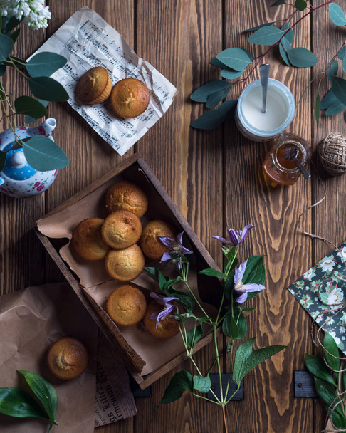 Muffins in wooden box with tea pot - 写真・画像
