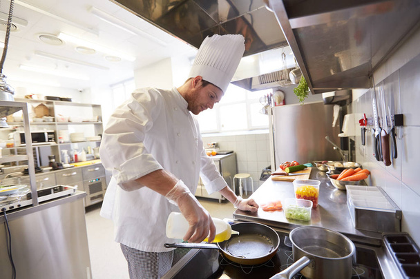 happy male chef cooking food at restaurant kitchen - Fotoğraf, Görsel
