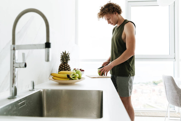 Homem concentrado de pé na cozinha e cozinhar
 - Foto, Imagem