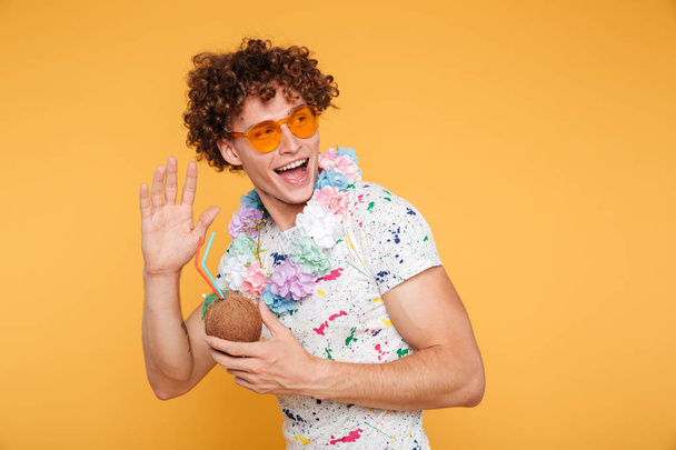 Excited young man in sunglasses holding coconut cocktail - Foto, imagen