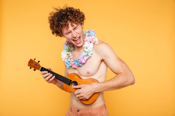 Attractive shirtless man in summer clothes playing ukulele - Zdjęcie, obraz