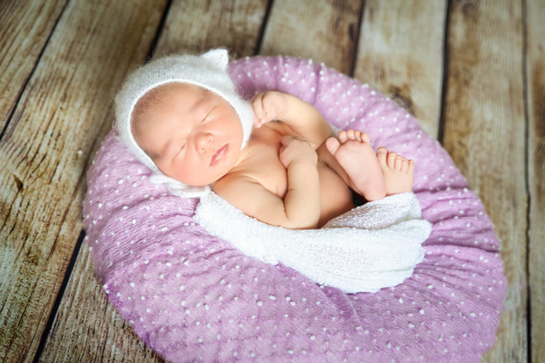 Sleeping newborn baby on a violet pillow - Foto, Imagem