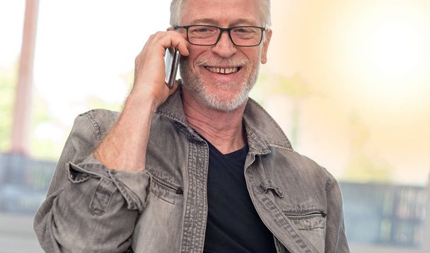 Портрет усміхненого зрілого чоловіка, що розмовляє по телефону, легкий ефект
 - Фото, зображення