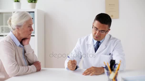 woman and doctor with prescription at clinic - Materiał filmowy, wideo