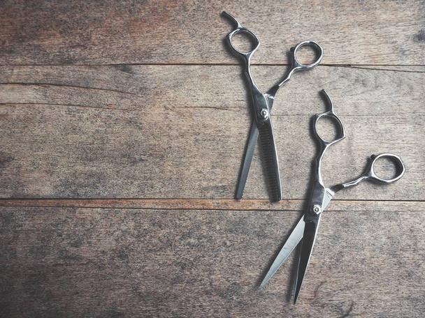 Pair of hair cutting shears on grungy wooden background - Фото, зображення