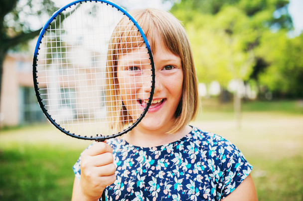 Portrait drôle d'été de petite fille jouant au badminton dans le parc vert
 - Photo, image