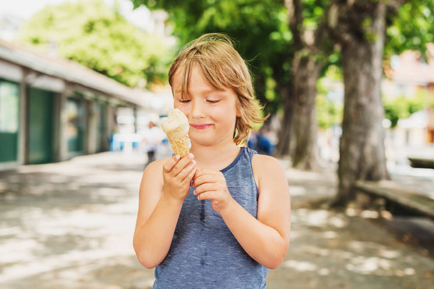 Portrait extérieur de drôle de petit garçon mangeant de la crème glacée par une chaude journée
 - Photo, image