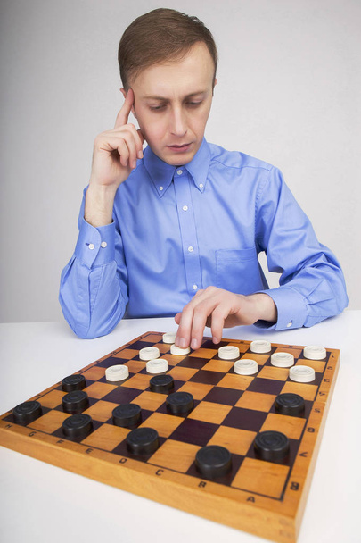 Man thinks and makes the game of checkers - Photo, image