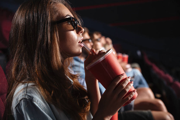 Lady sitting in cinema watch film drinking aerated sweet water. - Zdjęcie, obraz