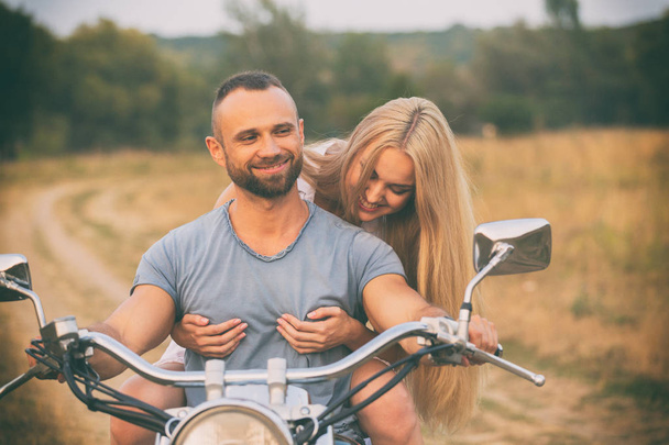 Young couple on a motorcycle in the field - Foto, immagini