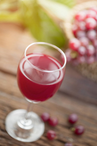 ワインやブドウ ジュースと木製のテーブルにフルーツのグラス - 写真・画像