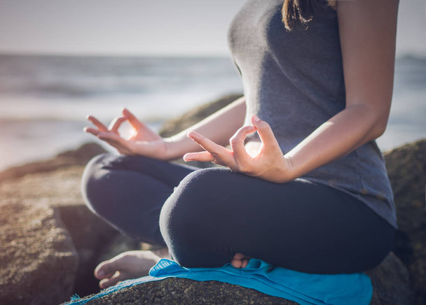 Yoga-Konzept. Nahaufnahme Frau Hand praktiziert Yoga am Strand - Foto, Bild