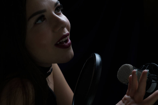 Bella ragazza che canta In Recording Studio con microfono
 - Foto, immagini