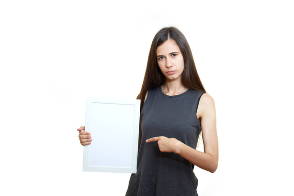 The girl is holding a poster. White background. Emotions - Φωτογραφία, εικόνα