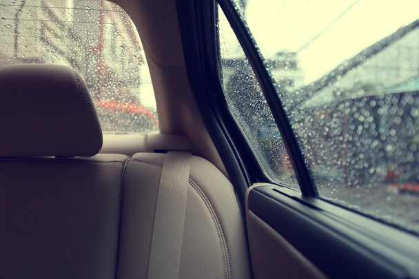 雨で車の中の後部座席をウィンドウにドロップします。 - 写真・画像
