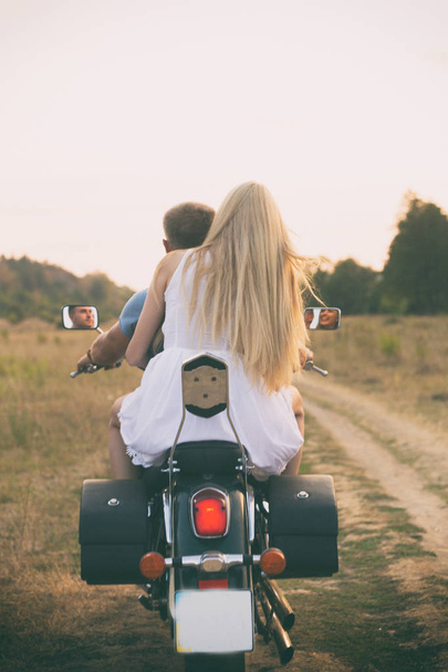 Jeune couple sur une moto dans le domaine
 - Photo, image
