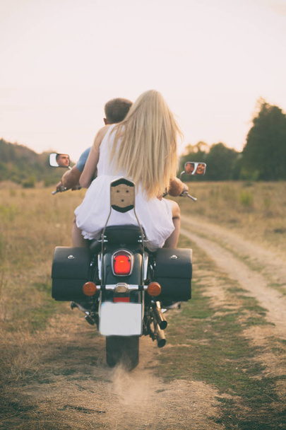 Jeune couple sur une moto dans le domaine
 - Photo, image