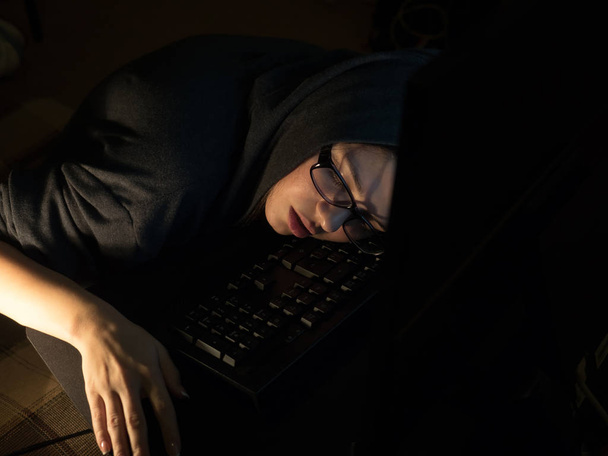Hacker girl sleeping beside laptop - Fotografie, Obrázek