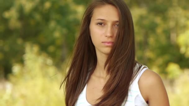 Portrét mladé krásné usměvavé ženy na pozadí zelené letní městský park. - Záběry, video