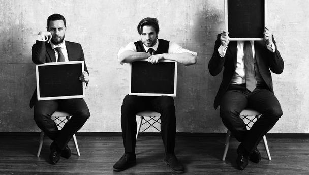 businessman, serious boss man and employee guy holding blackboar - Valokuva, kuva