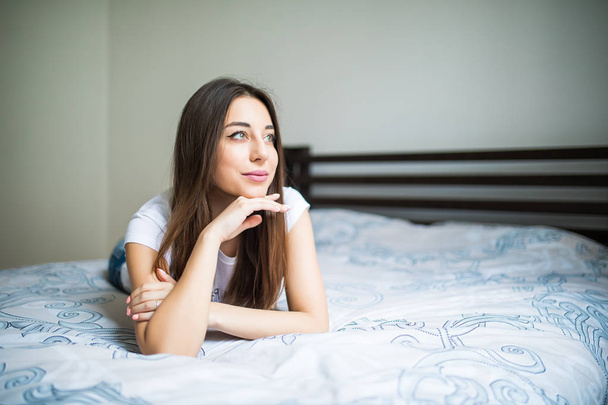 Πορτρέτο του ένα όνειρα όμορφη νεαρή γυναίκα ξαπλωμένη στο κρεβάτι - Φωτογραφία, εικόνα