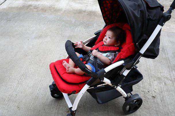 bebé niño lindo en el asiento del cochecito del niño en rueda
 - Foto, imagen