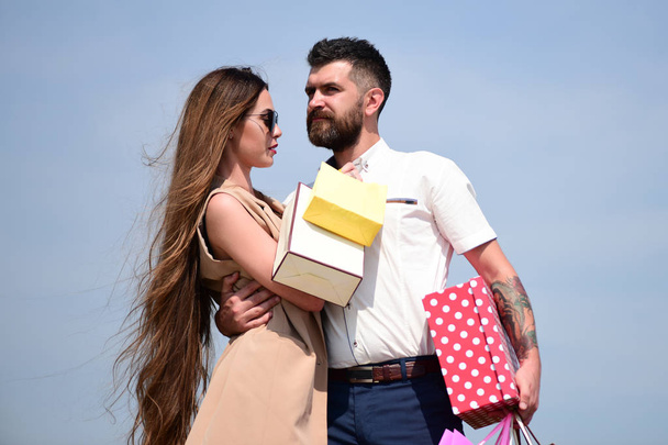 Couple carries pink packets and box isolated on blue background - Foto, afbeelding