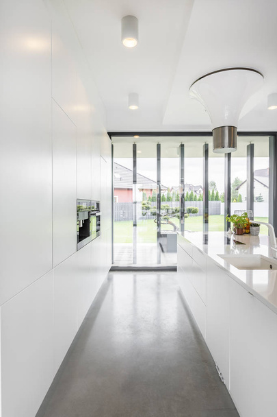 Bright, minimalist kitchen outlooking patio - Zdjęcie, obraz