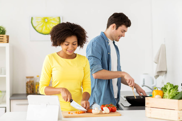 happy couple cooking food at home kitchen - Foto, imagen