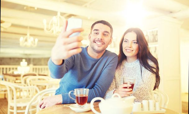 couple taking smartphone selfie at cafe restaurant - Foto, imagen