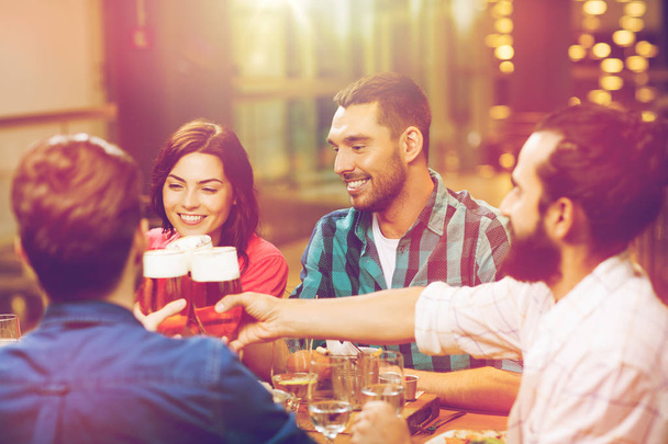 vrienden dineren en bier drinken in restaurant - Foto, afbeelding