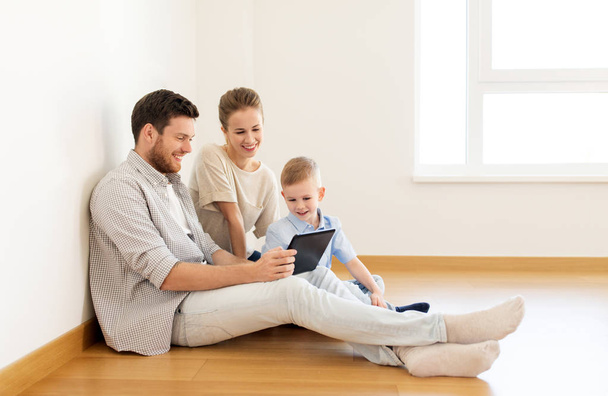 happy family with tablet pc moving to new home - Фото, изображение