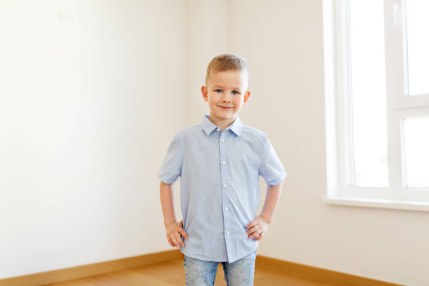 smiling little boy at empty room of new home - Foto, Imagen