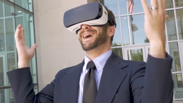 Businessman celebrating victory in a virtual reality experience with VR goggles - Záběry, video