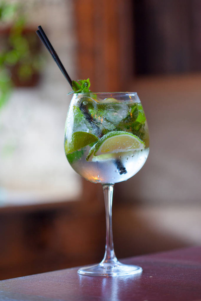 Glass tank mojito at the bar closeup. refreshing drink with Fresh mint, limes, sugar - Photo, image
