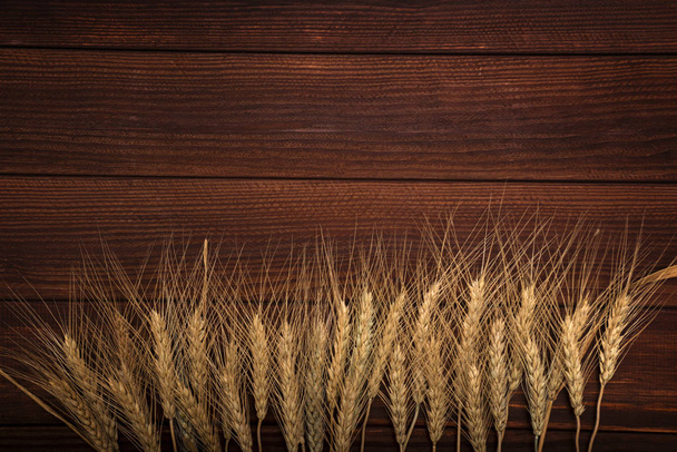 пшеничные уши на деревянном фоне - Фото, изображение