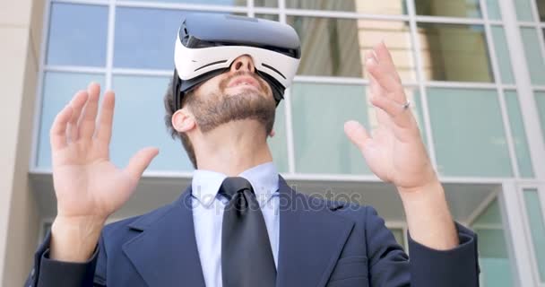 Male business executive enjoying virtual reality with VR headset outside - Metraje, vídeo