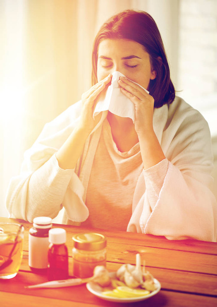 sick woman with medicine blowing nose to wipe - Foto, Bild