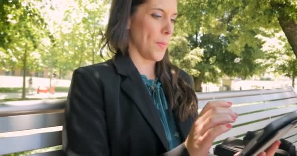 Attractive woman remembering something and smiling while on digital tablet - Materiał filmowy, wideo