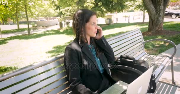 Бізнес-леді працює на ноутбуці і розмовляє на мобільному телефоні
 - Кадри, відео