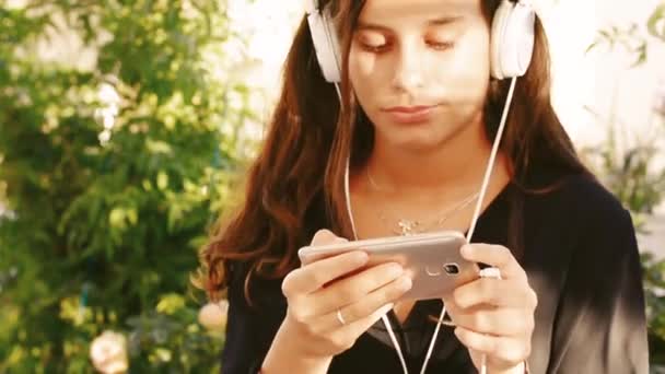 woman listening music with headphones and smart phone - Video