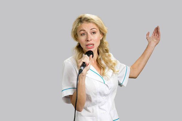 Jeune infirmière gesticulant microphone d'exploitation
. - Photo, image