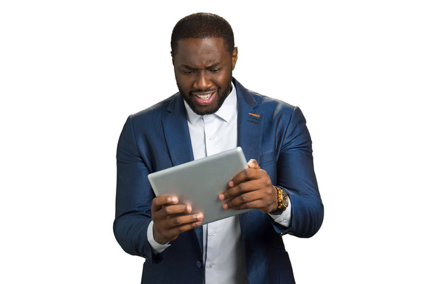 Fekete üzletember meglepve nézett tabletta számítógép. - Fotó, kép