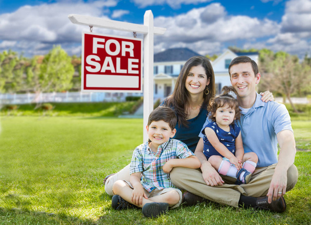 junge Familie mit Kindern vor maßgeschneidertem Haus und zum Verkauf stehenden Immobilienschild. - Foto, Bild