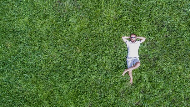 Hombre acostado en una hierba
 - Foto, Imagen